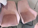 une paire de fauteuils en velours rose aux pieds en métal noir dans une pièce