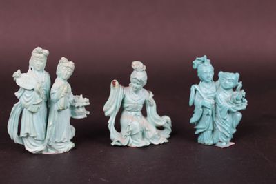 three chinese figurines of women and a man on a black surface