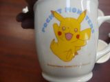 a person holding a coffee cup with a pikachu on it