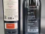 two bottles of red wine sitting next to each other on a table