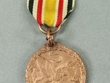 a gold medal with a red, white, and black ribbon around it