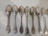 six cuillères en argent sont alignées sur une table