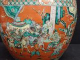a large orange vase with a picture of people on it