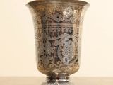 un vase en argent posé sur une table en bois