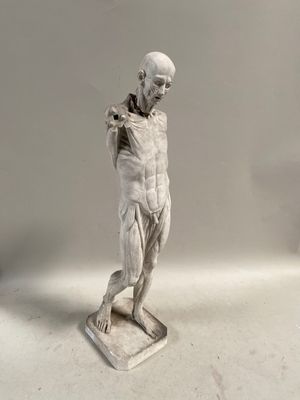 statue d'un homme tenant une raquette de tennis, posée sur une surface blanche
