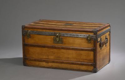 une vieille malle en bois munie de poignées métalliques et d'un loquet sur le dessus