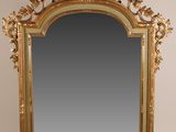 un miroir sculpté avec un cadre doré sur fond blanc