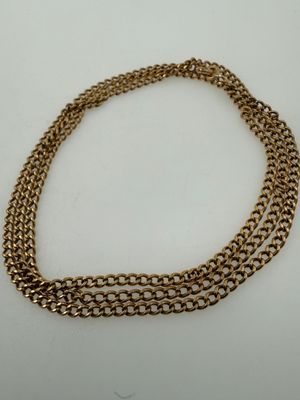 a close up of a gold chain necklace on a white surface