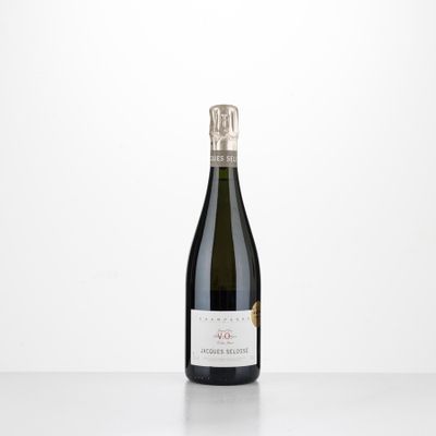 a bottle of wine sitting on top of a table next to a white wall