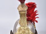 helmet of a soldier with a red feather on top of it