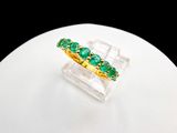 une image représentant une bague ornée de pierres vertes