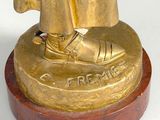a gold statue of a man in a robe and shoes