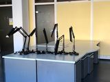 cinq bureaux dans une pièce, sur lesquels sont posées trois lampes