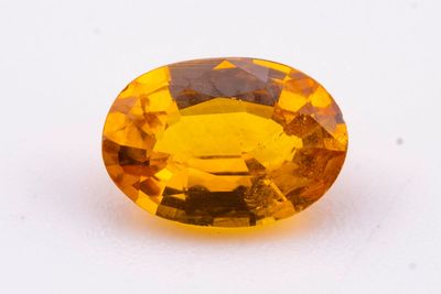 gros plan d'une pierre de saphir jaune sur une surface blanche
