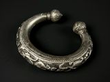 gros plan d'un bracelet en argent sur une surface noire