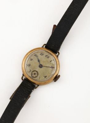 an old wrist watch with a black leather band and a gold face