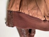 a close up of a person ' s legs with a brown skirt