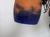 a blue and orange vase hanging on a wall