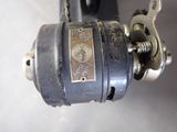 a close up of a sewing machine with a chain attached to it