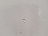 a close up of a white plate with the word p on it