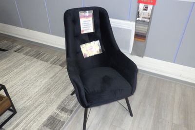 une chaise noire qui se trouve dans un coin de la pièce
