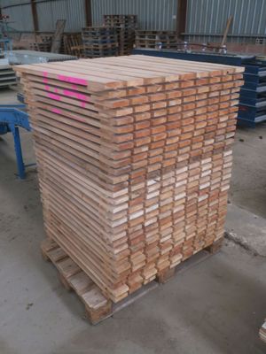 plusieurs piles de planches de bois empilées les unes sur les autres dans un entrepôt