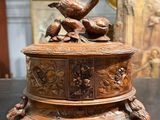 a wooden box with birds on top of it on a table