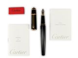 the fountain pen is next to a notepad and a red box