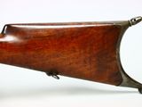 a close up of a rifle on a white surface with a white background