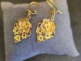 un gros plan sur une paire de boucles d'oreilles posées sur un oreiller