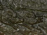 a close up of a bronze sculpture of a man and a boar