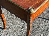 a small table with a wooden top on a gravel ground