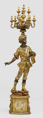a statue of a man holding a chandelier on top of a table