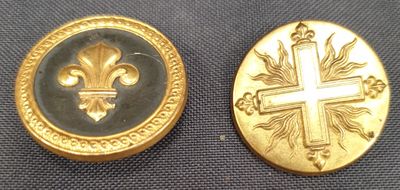 deux boutons plaqués or ornés d'une croix et d'une fleur de lys