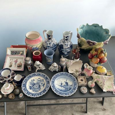 une table sur laquelle sont disposées de nombreuses pièces de poterie de styles variés