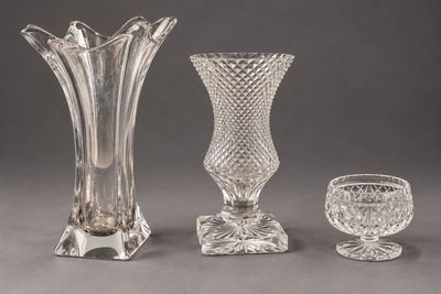 trois vases en verre et un gobelet en verre posés sur une table