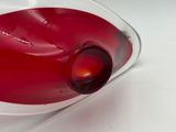 a red liquid in a glass bowl on a white surface