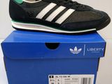 une paire de baskets noires et vertes posée sur une boîte bleue