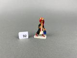 un gros plan sur une petite figurine représentant un homme coiffé d'un chapeau rouge