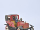 a red toy car with a man sitting in it