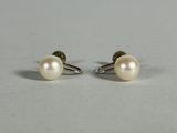 a pair of pearl earrings on a white surface
