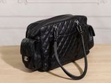 black quilted purse on a wooden table in front of a white wall