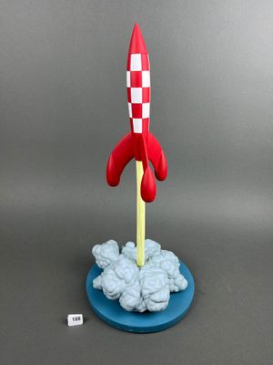 a toy rocket that is sitting on top of a blue plate