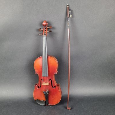 un violon avec un archet et une canne à côté