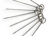 six stainless steel knitting needles on a white surface with a white background