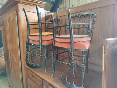 four chairs that are sitting on top of a wooden cabinet