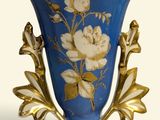 un vase bleu orné de fleurs blanches, posé sur une surface blanche