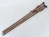 une paire de bâtons de ski en bois avec des poignées noires sur un fond blanc
