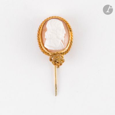 une image représentant une broche-cameo dorée et blanche ornée d'une corde