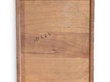an old wooden box with writing on it sitting on a white surface